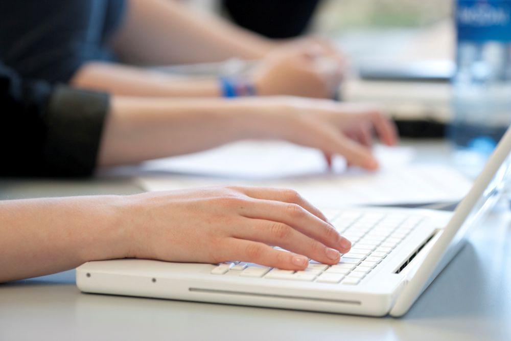 Hender som skriver på et tastatur